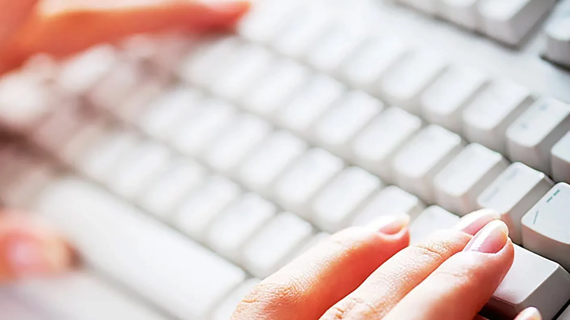 Eine Frau tippt in eine Tastatur