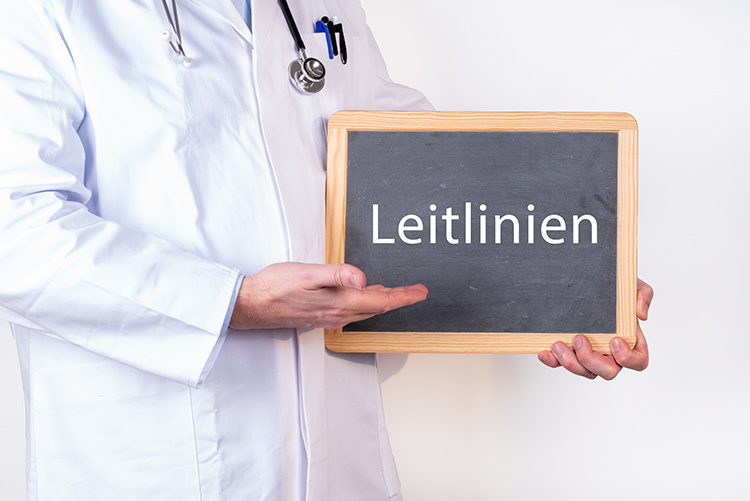 Arzt mit einer Tafel zu Leitlinien-HNFoto – AdobeStock_382326880