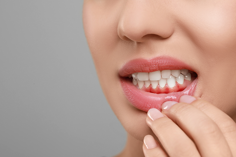 Woman showing inflamed gum on grey background, closeup. Space for text-New Africa-AdobeStock_690436736
