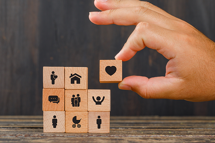 Versicherung-relationship-concept-wooden-table-side-view-hand-holding-wooden-cube-with-heart-icon-8photo-freepik.com-9486197