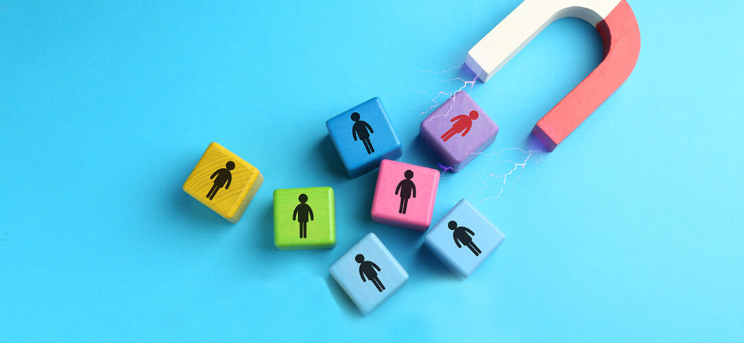 Magnet attracting colorful cubes with human figures on light blue background, top view. Recruitment or customer acquisition