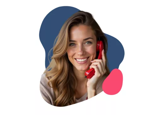 Lächelnde Frau halt einen roten Telefonhörer in der Hand/ an ihr Ohr