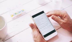 Patient füllt am Handy ein Onlineformular aus.