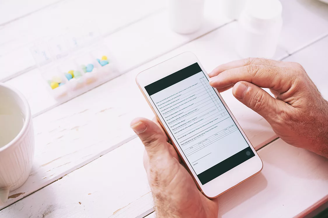 Patient füllt am Handy ein Onlineformular aus.