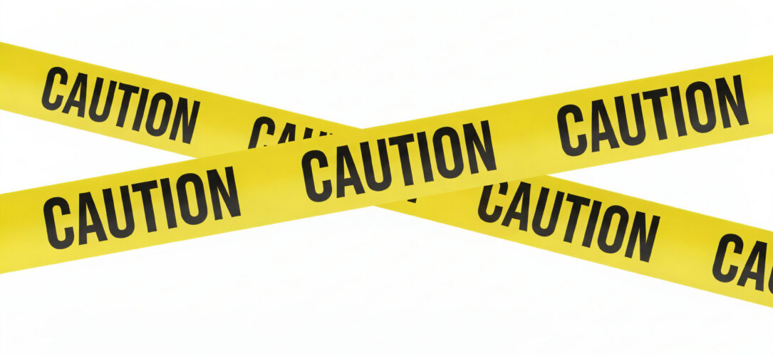 Yellow caution tape with the word "CAUTION" written repeatedly in black. The tape is crossed in an "X" shape against a plain white background.