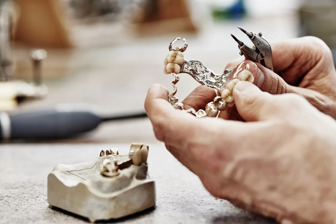 Hand arbeitet an Zahnkronenmodell