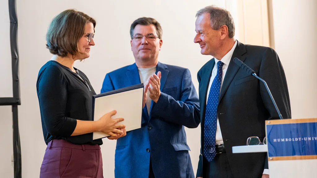 Jörg Wiltfang (r), Präsident der Deutschen Gesellschaft für Zahn-, Mund- und Kieferheilkunde (DGZMK), und Kay Lutze (m), Historiker und Nachfahre von Verfolgten, überreicht den Hans-Türkheim-Preis an Lisa Bitterich, Preistägerin des Hans-Türkheim-Preises.