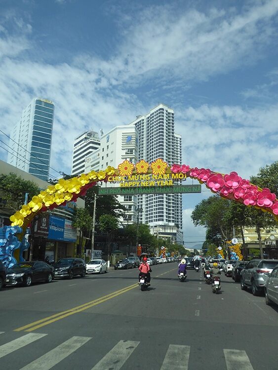 Ein klarer Himmel, Hochhäuser und ein Bogen mit Blumen verziert.