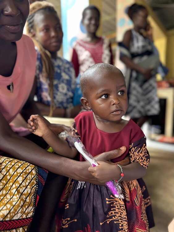 Ein Kleinkind hält eine Zahnbürste in der Hand.