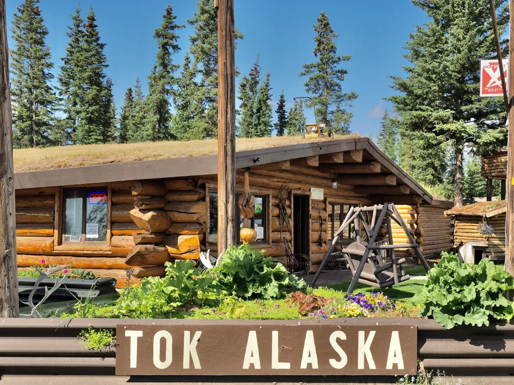 Blockhäuser dominieren Tok, der Rasenmäher auf dem Dach ist nur Zierde.