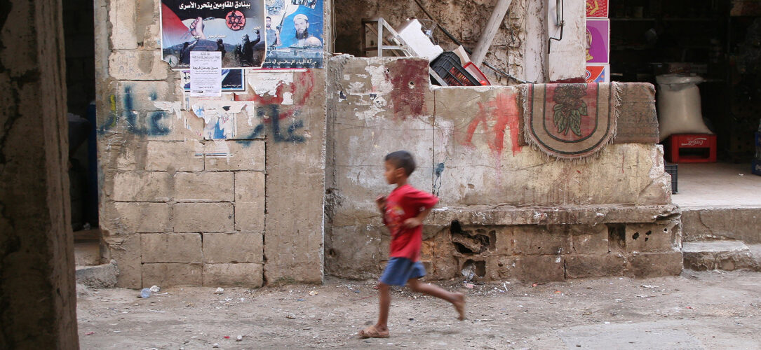 Ein kleiner Junge rennt durch das Flüchtlingslager Schatila