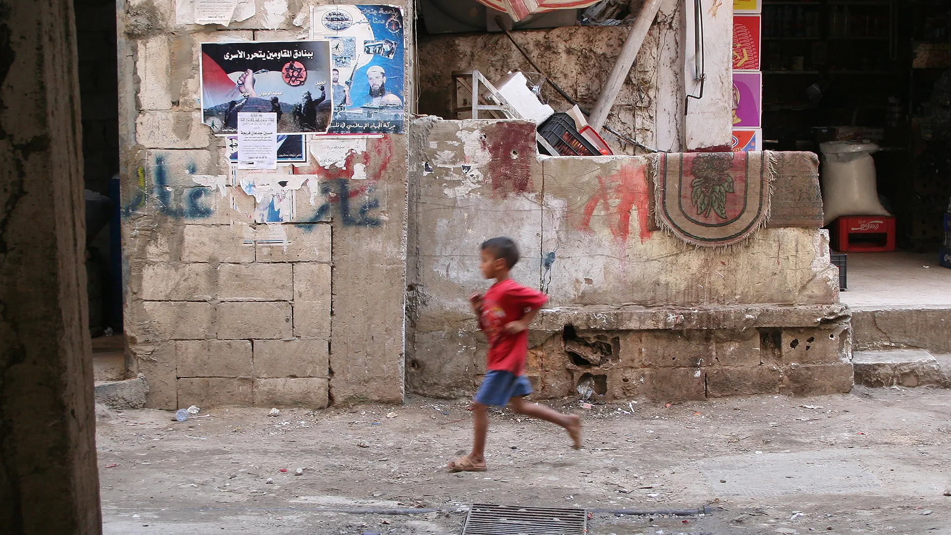 Ein kleiner Junge rennt durch das Flüchtlingslager Schatila