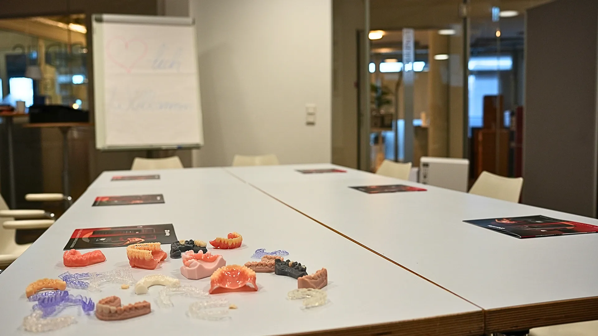 Ein Tisch auf dem verschiedene 3D Kiefermodelle sind.