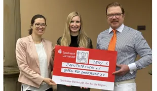 Herr Dr. Rath, Geschäftsführer des VfZ, überreicht Frau Dr. Thome (links) und Frau Dr. Aurin (mitte) den symbolischen Spendenscheck