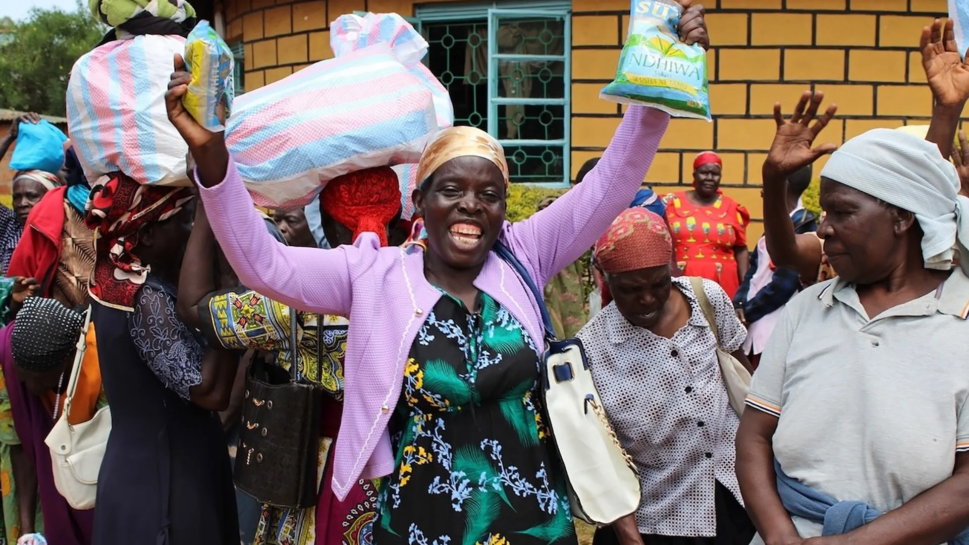Eine Gruppe von lachenden Frauen, die sich über die Spenden freuen.