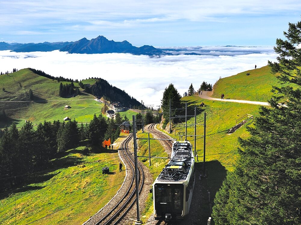Die Rigi-Bahn fährt durch eine schöne Landschaft.