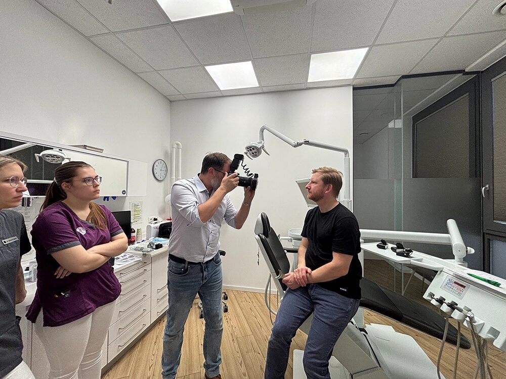 ein Mann sitzt für die Bilder seitlich auf dem Behandlungsstuhl