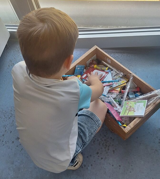 Ein Kind mit einer Spielzeugkiste.