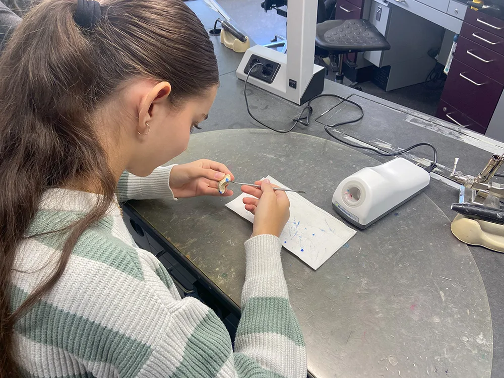 Eine Schülerin formt etwas aus Wachs