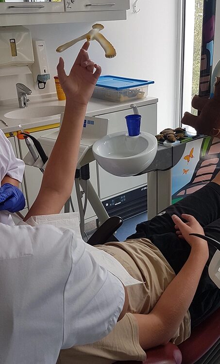 Eine Kinderhand auf der er ein Spielzeug balanciert.