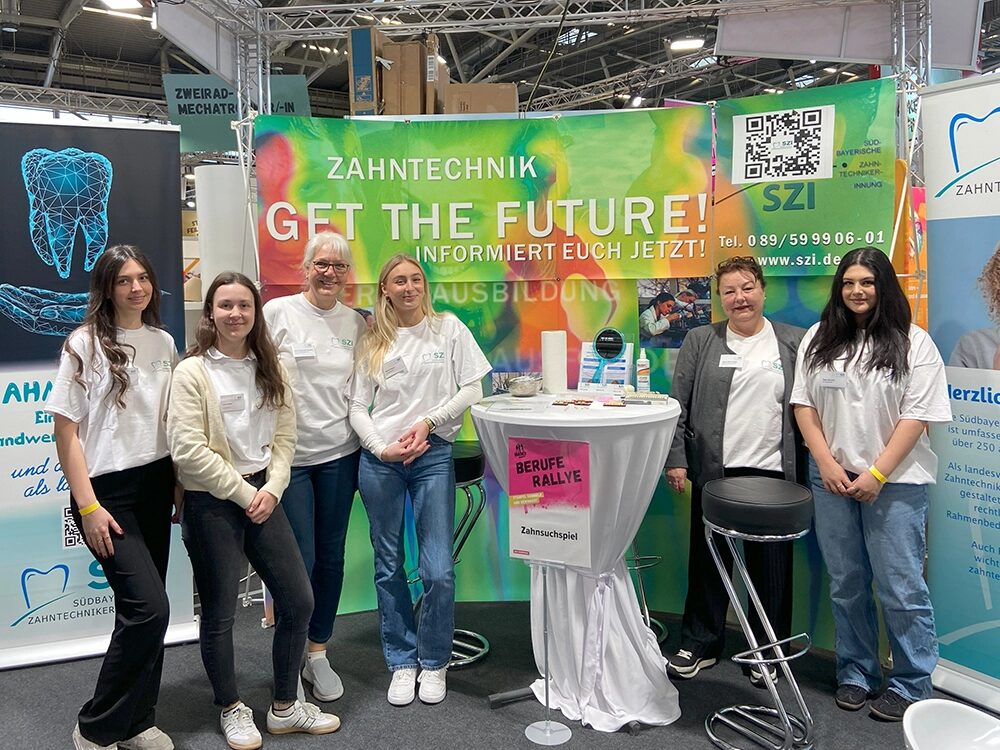 Poster der Ausbildungsmesse im Hintergrund, davor Auszubildende mit den Ausbilder/-innen.