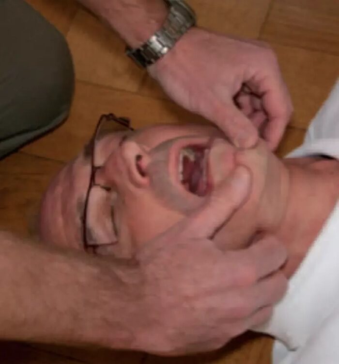 mit den Fingern den Mund am Kinn nach unten ziehen