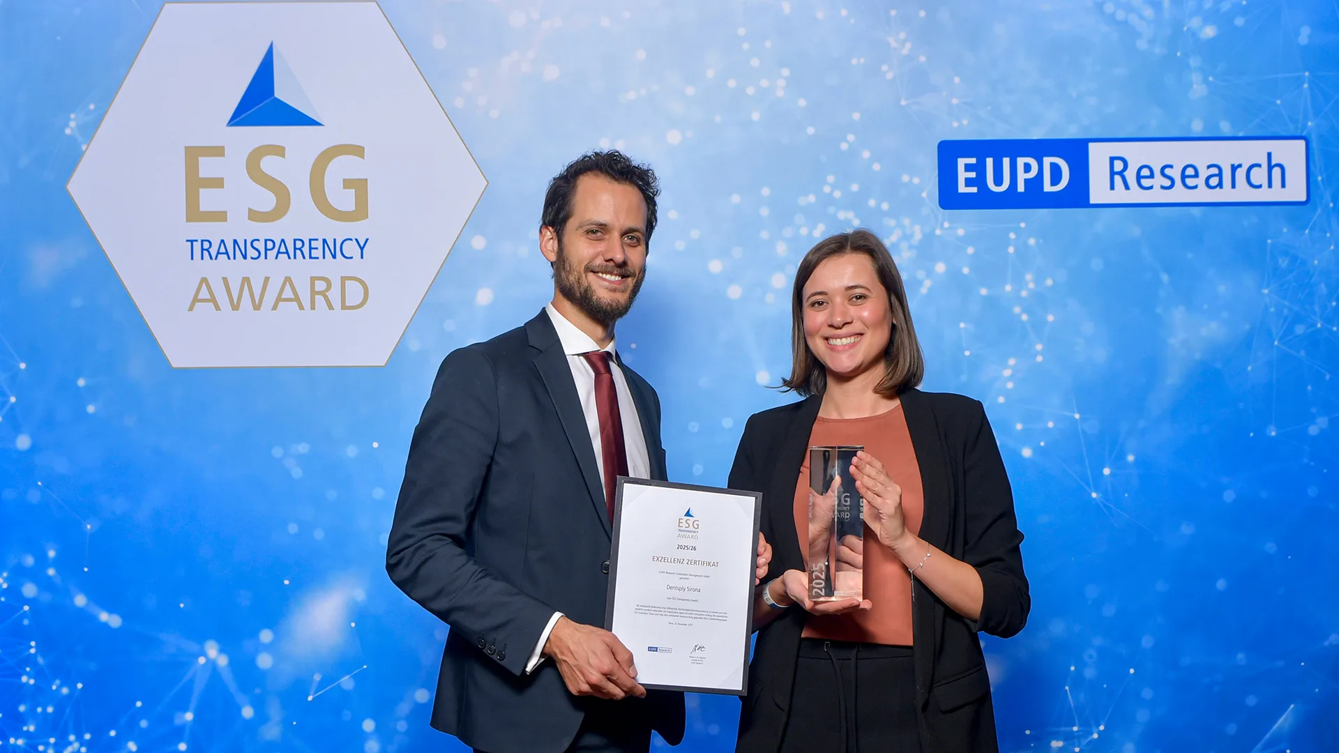 Steffen Klink, COO der EUPD Group, überreicht Sarah Mayer, Corporate Communications Manager bei Dentsply Sirona, während des ESG Summits am 26. November in Bonn das ESG-Transparenzzertifikat.