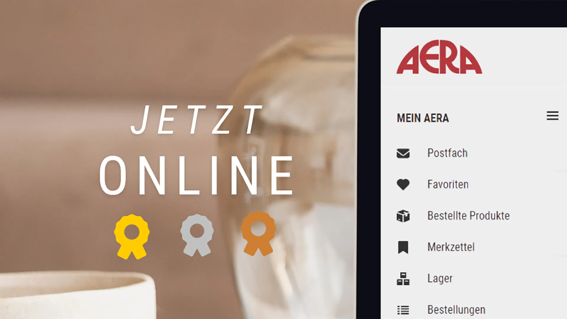drei Medaillen, daneben ein Laptop mit dem AERA Logo.