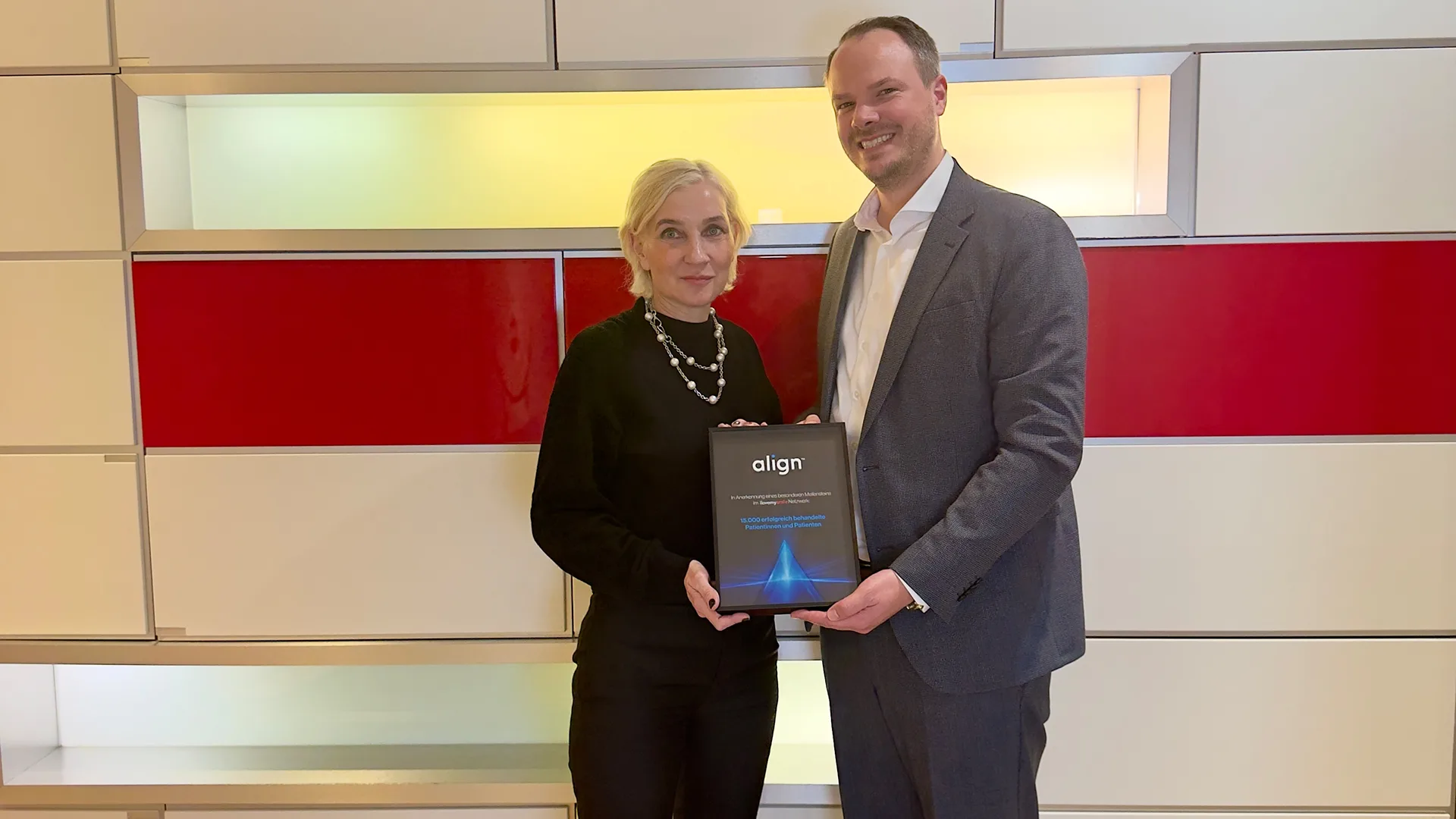 Philipp Eichler, Align Technology DACH, gratuliert Dr. Angelika Frankenberger, Gründerin von I Love My Smile, zu 15.000 erfolgreich durch das Netzwerk behandelten Patientinnen und Patienten.