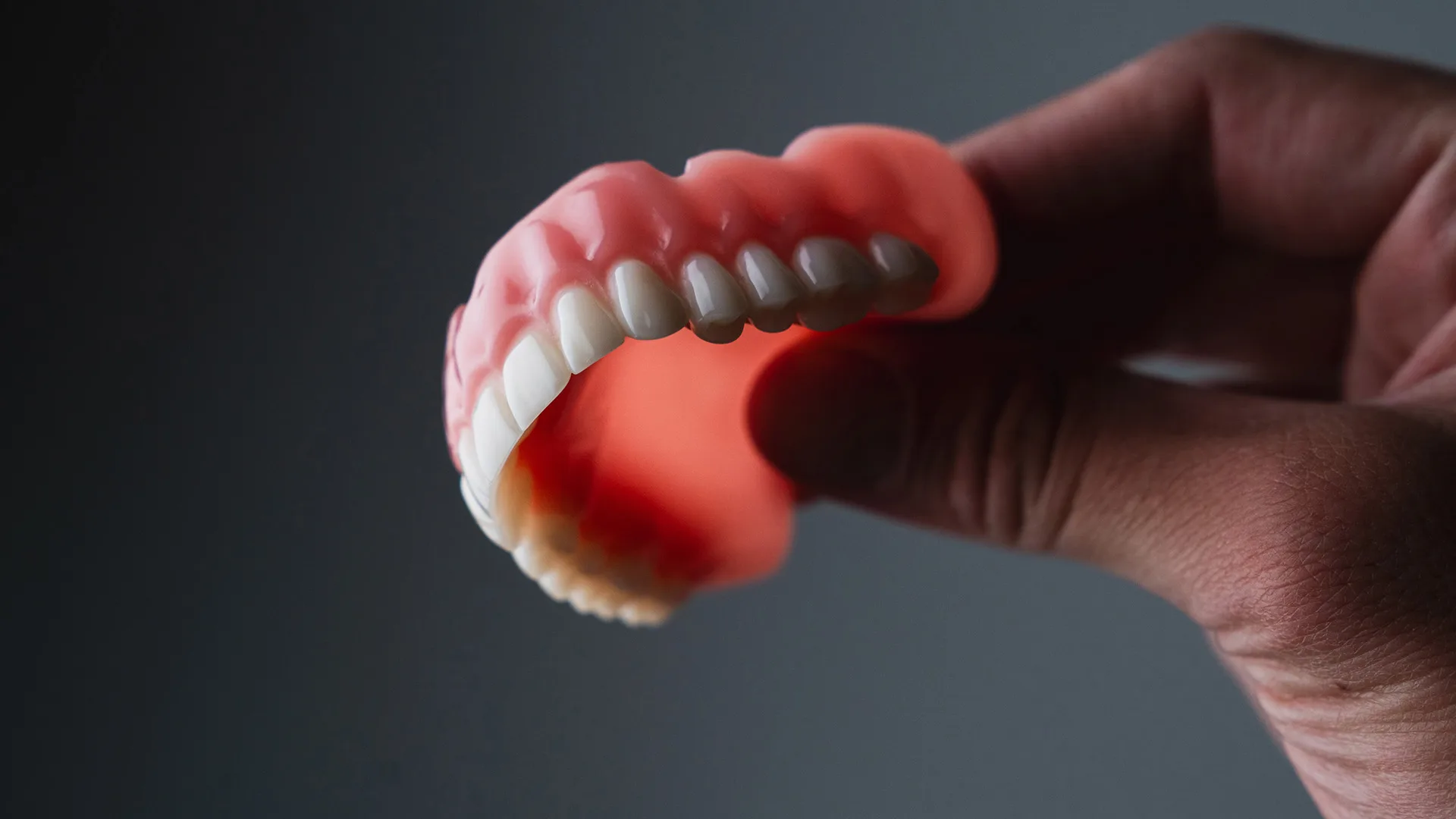 Eine Hand die ein Gebiss hält.