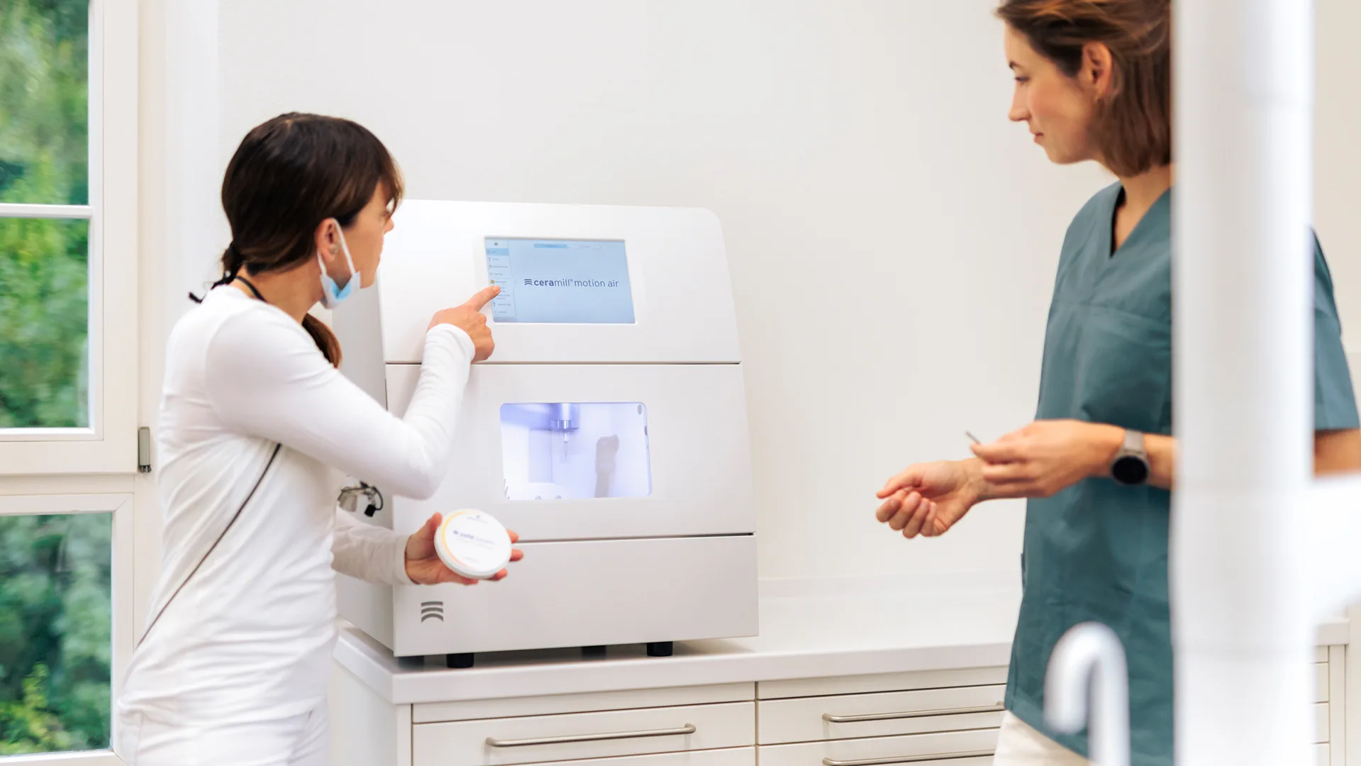 Zwei Frauen schauen sich ein Gerät näher an