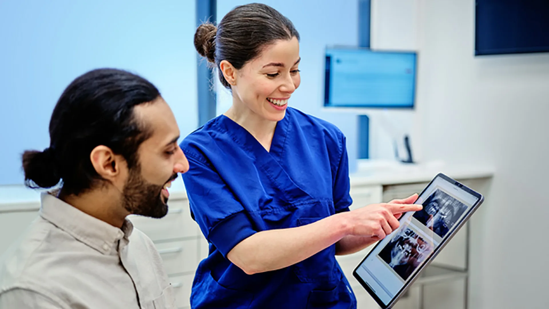 Eine Frau erklärt einem Patienten den Behandlungsplan.