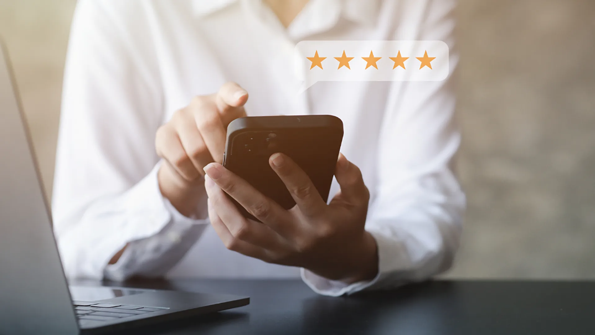 Eine Frau hält ein Handy in der Hand und gibt eine Bewertung ab, über dem Handy sind 5 Sterne.