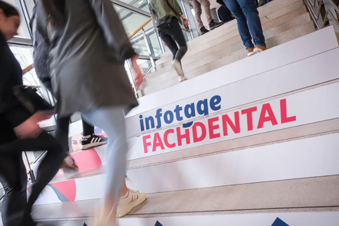 Menschen die Treppen hochlaufen und auf der Treppe folgender Schriftzug: Infotage Fachdental