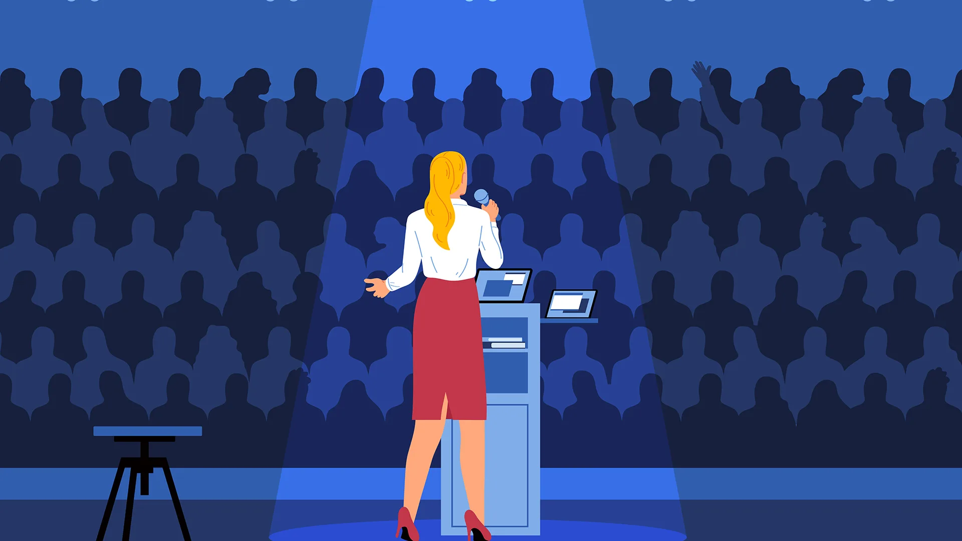 Frau spricht auf einer Bühne vor Publikum