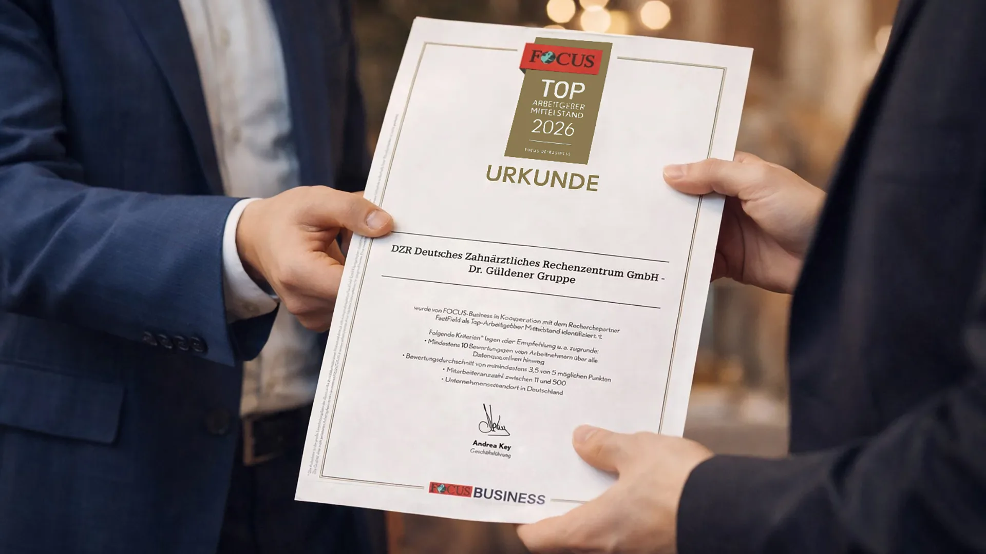 eine Urkunde wird von zwei Händen gehalten