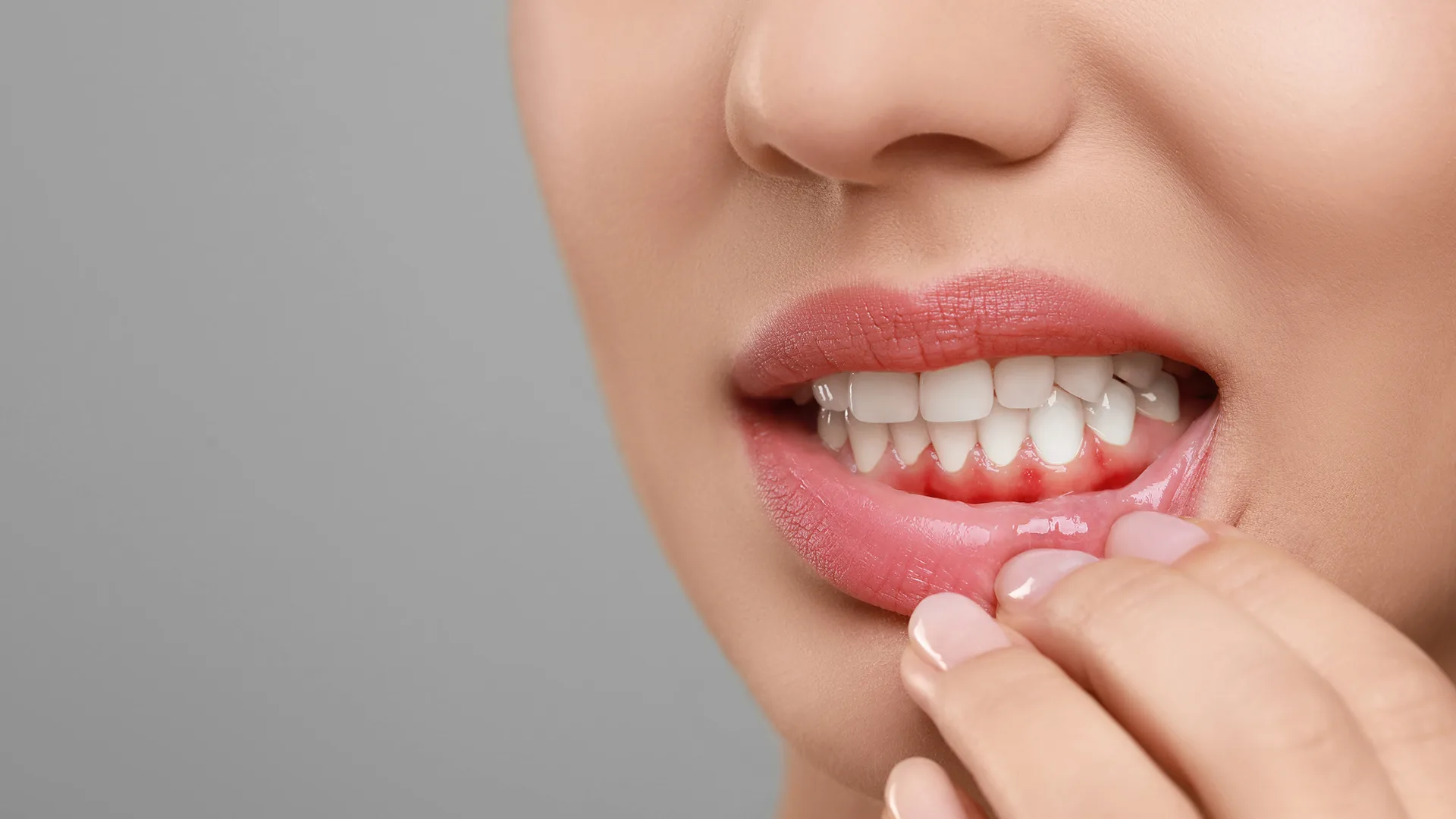 Eine Frau fasst sich an die Lippe.