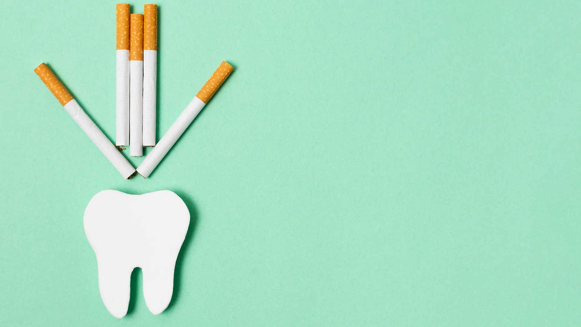 Zigaretten die einen Pfeil bilden und auf einen Zahn zeigen.