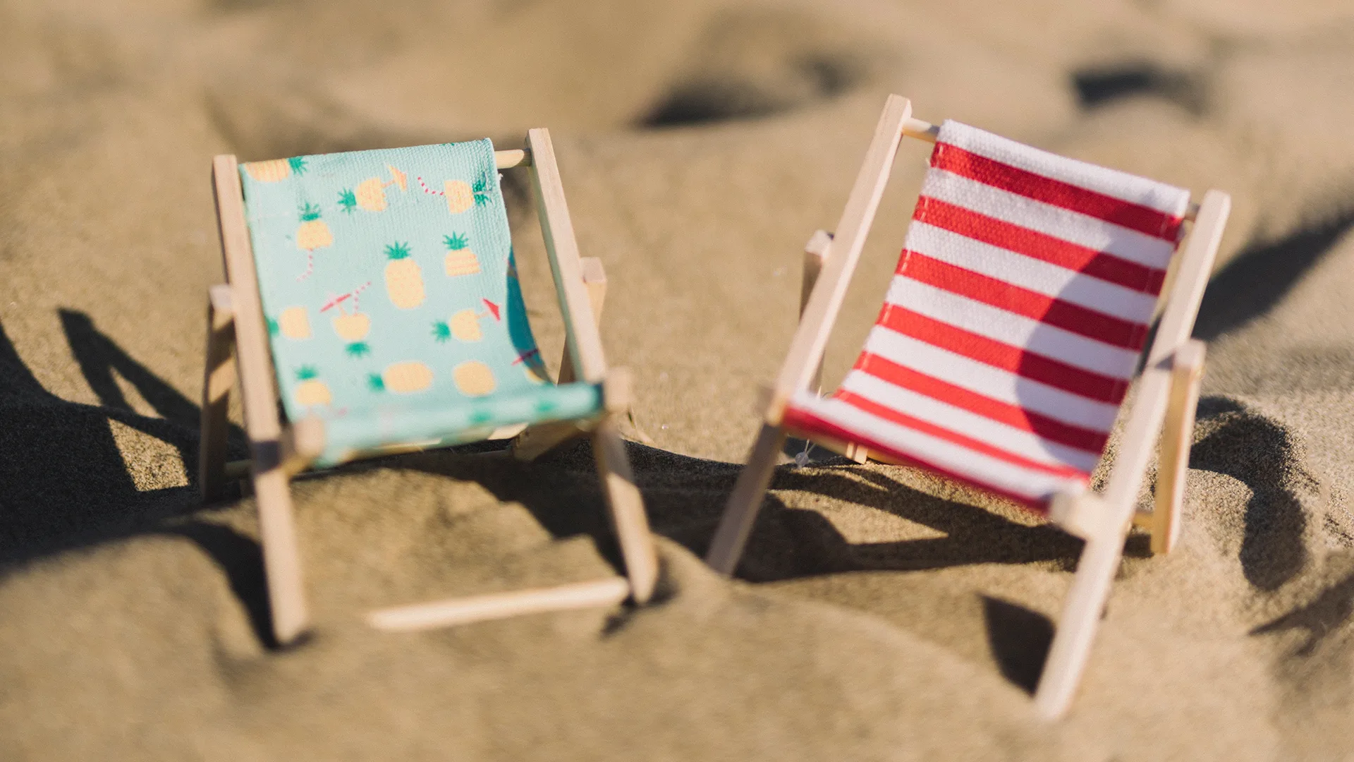 Zwei Liegestühle im Sand