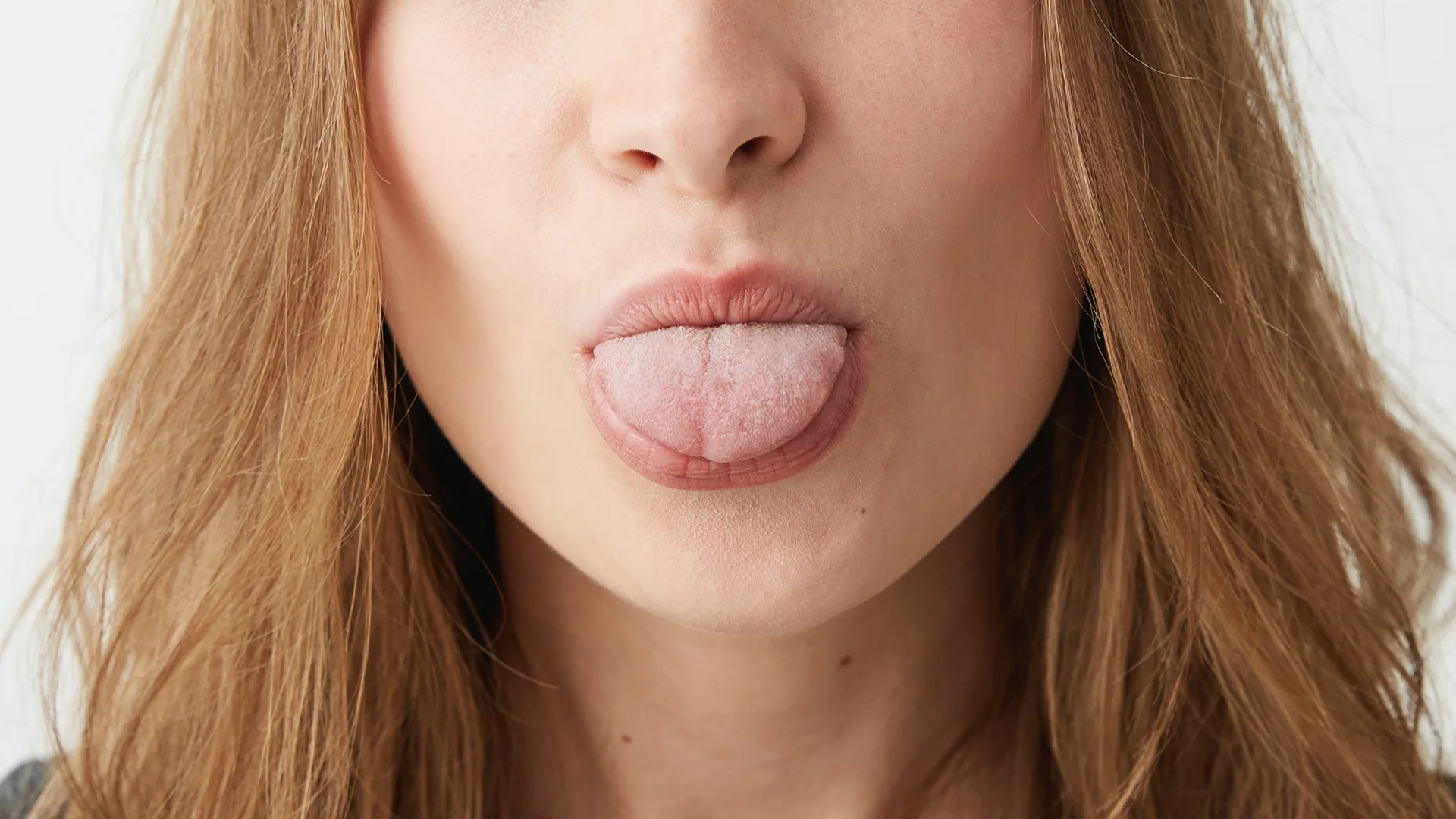 Eine Frau streckt ihre Zunge raus.