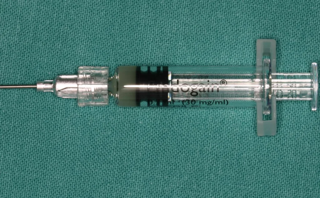 Abb. 2a u. b: Die erste kommerziell verfügbare Darreichung von SMP bestand anfänglich noch aus zwei Komponenten – dem Amelogenin-haltigen Proteingemisch und dem PGA-Trägergel. Vor der Applikation in den entsprechenden parodontalen Defekt mussten die Komponenten gemischt werden. Später wurde dann eine Ready-to-Use-Spritze eingeführt, welche das klinische Vorgehen vereinfacht.