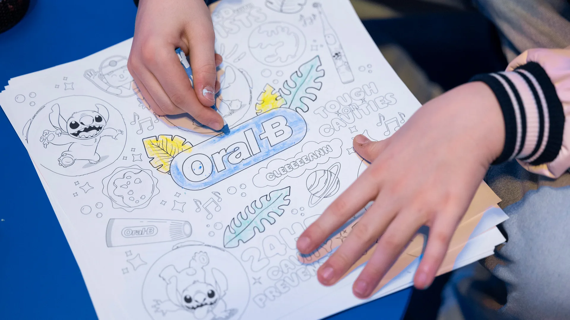 Ein Kind malt das Oral-B Logo aus.