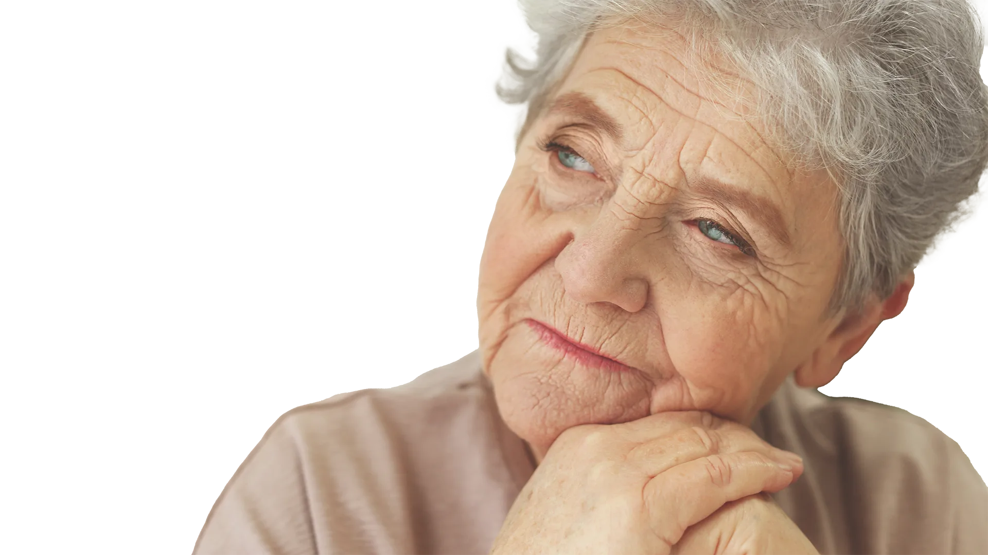 Eine ältere Frau stützt ihr Kinn auf ihren Händen und schaut weg.