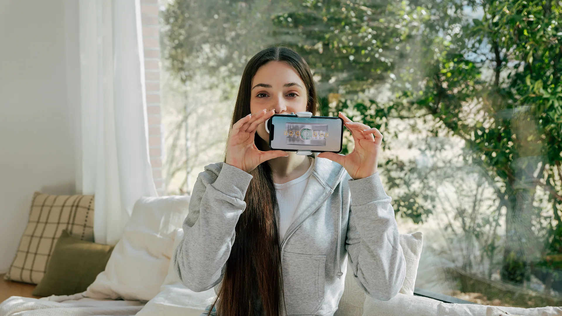 Eine Frau hält ihr Smartphone vor ihren Mund.
