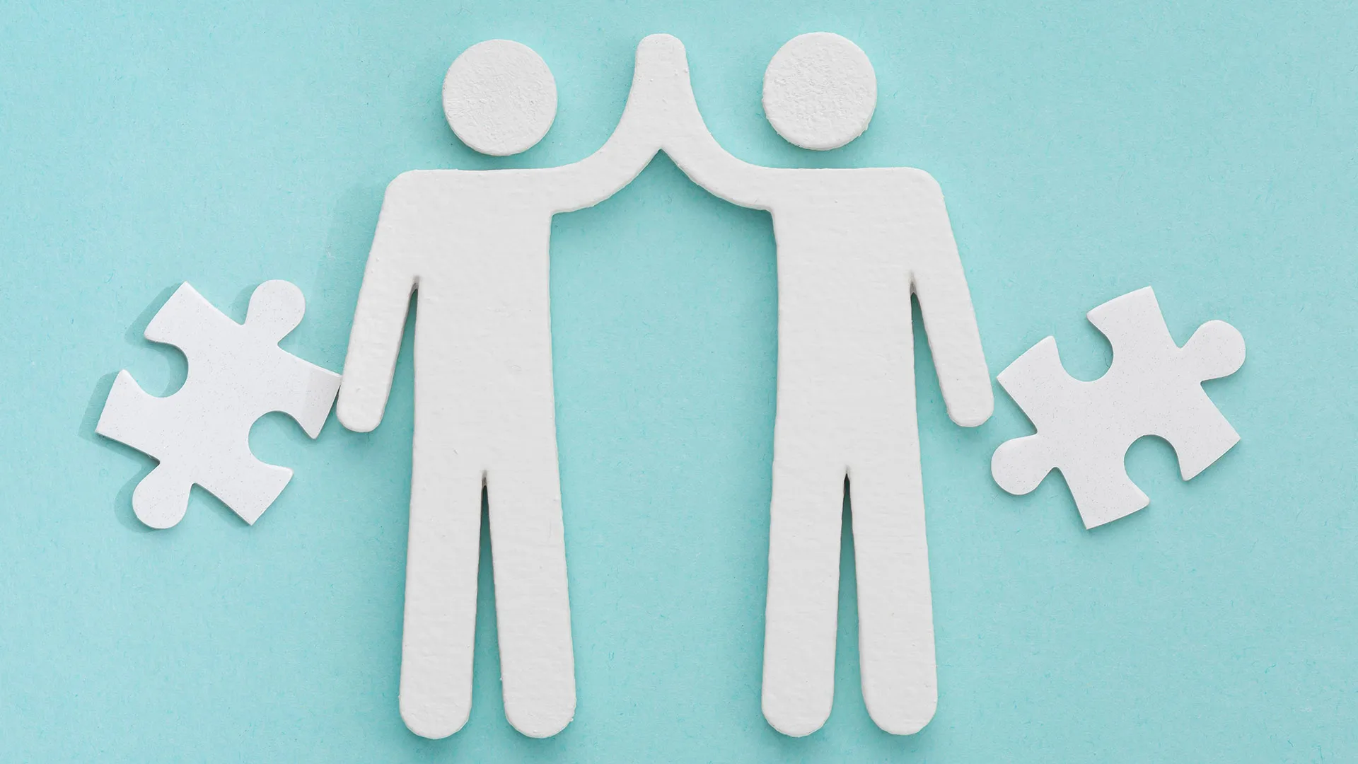 Illustration zweier Figuren, die in die Hände einklatschen und daneben Puzzleteile.