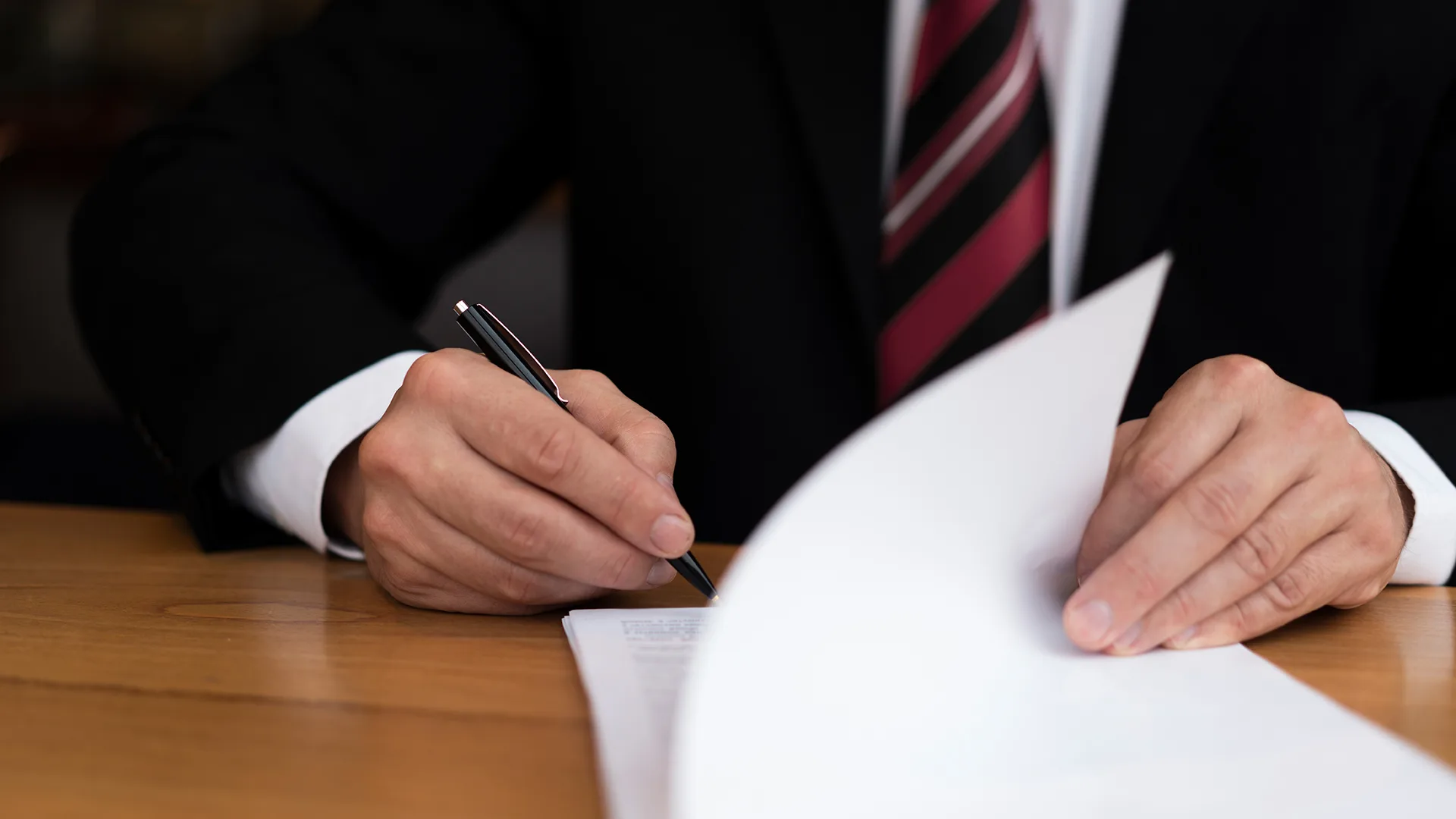 Ein Mann unterschreibt Papiere.