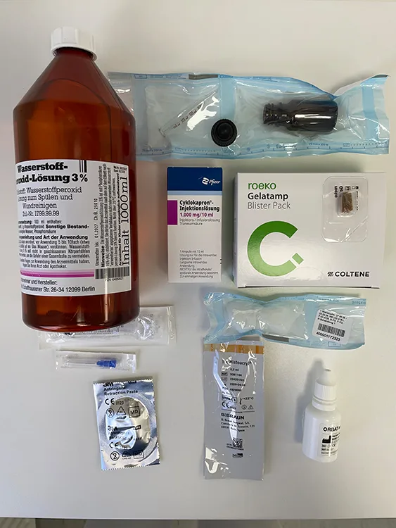 Abb. 8 a u. b: Auswahl des medikamentösen und apparativen Armamentariums zur Blutstillung unterschiedlichen Ausmaßes. (a) Wasserstoffperoxid-Lösung 3% (Paul W. Beyvers), roeko Gelatamp (Coltene), Cyklokapron-Injektionslösung (Pfizer), Astringent Retraction Paste (3M), Histoacryl (Braun), Orbat (lege artis Pharma). Die Anwendung von Histoacryl®-Gewebekleber entspricht einem «off-label-use» (englisch). Das bedeutet die Verwendung dieses Fertigarzneimittels erfolgt außerhalb des durch die Arzneimittelbehörden und via Beipackzettel zugelassenen Gebrauchs. [58]. Hinsichtlich der Anwendung dieser sehr hilfreichen Produktgruppe der Cyanoacrylate besteht gute externe Evidenz im Sinne entsprechender publizierter Berichte und/oder klinischer Studien. Andererseits liegt aber auch interne Evidenz durch langjährige klinische und darüber hinaus auch ausgesprochen positive Erfahrung vor, z. B. bei der Fixierung freier Schleimhauttransplantate in der oft auch stärker blutenden Empfängerregion [59-61]. (b) Nahtmaterialien unterschiedlicher Materialien und Stärke, parodontal-chirurgisches Grundinstrumentarium zur Blutstillung (Hu-Friedy), sterile Tupfer, Arterienklemme, Anästhetikum mit Adrenalinzusatz.