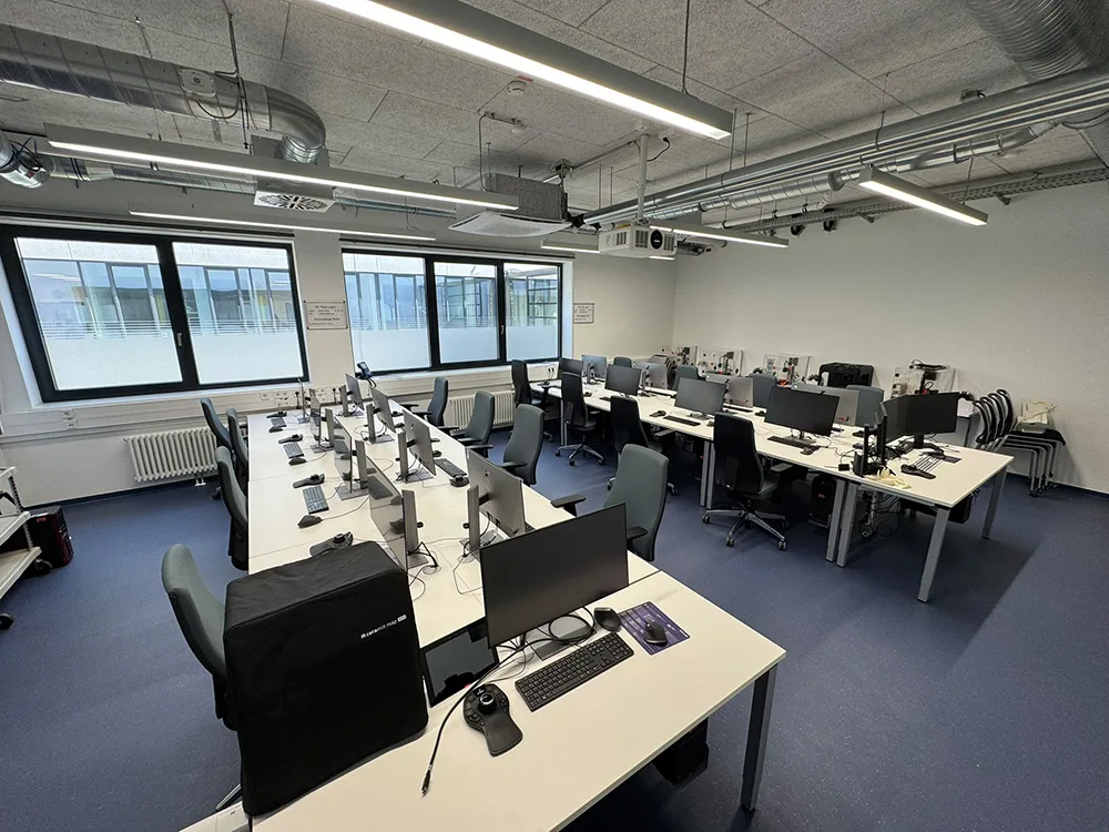 Abb. 4: CAD-Raum in den Skills Labs an der Universitätsklinik für Zahn-, Mund- und Kieferheilkunde Tübingen; 16 + 1-Supervisions-PC für 3D-Konfiguration und -Designapplikationen. Der Supervisions-PC erlaubt Zugriff auf alle 16 Trainings-PCs inkl. Spiegelung der Bildschirme an die Präsentationswand zwischen den Reihen (nicht im Bild
