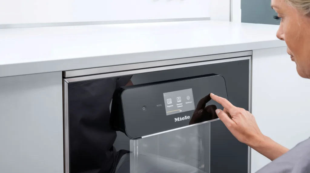 Mitarbeiterin schält die ExpertLine Dental von Miele ein.