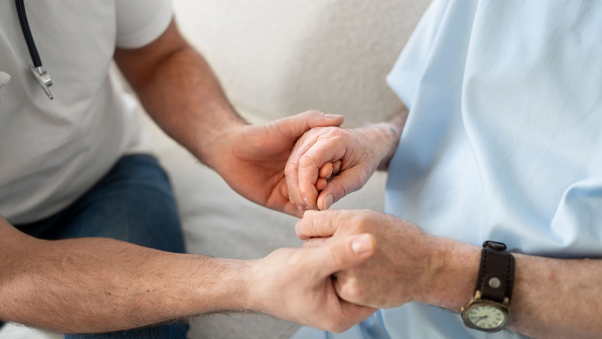 Ein Arzt hält die Hand eines Patienten.